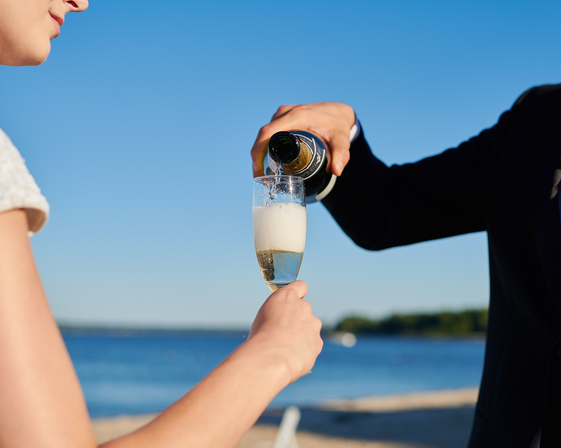 Couple enjoying champagne on the beach outside Greentree Country Club